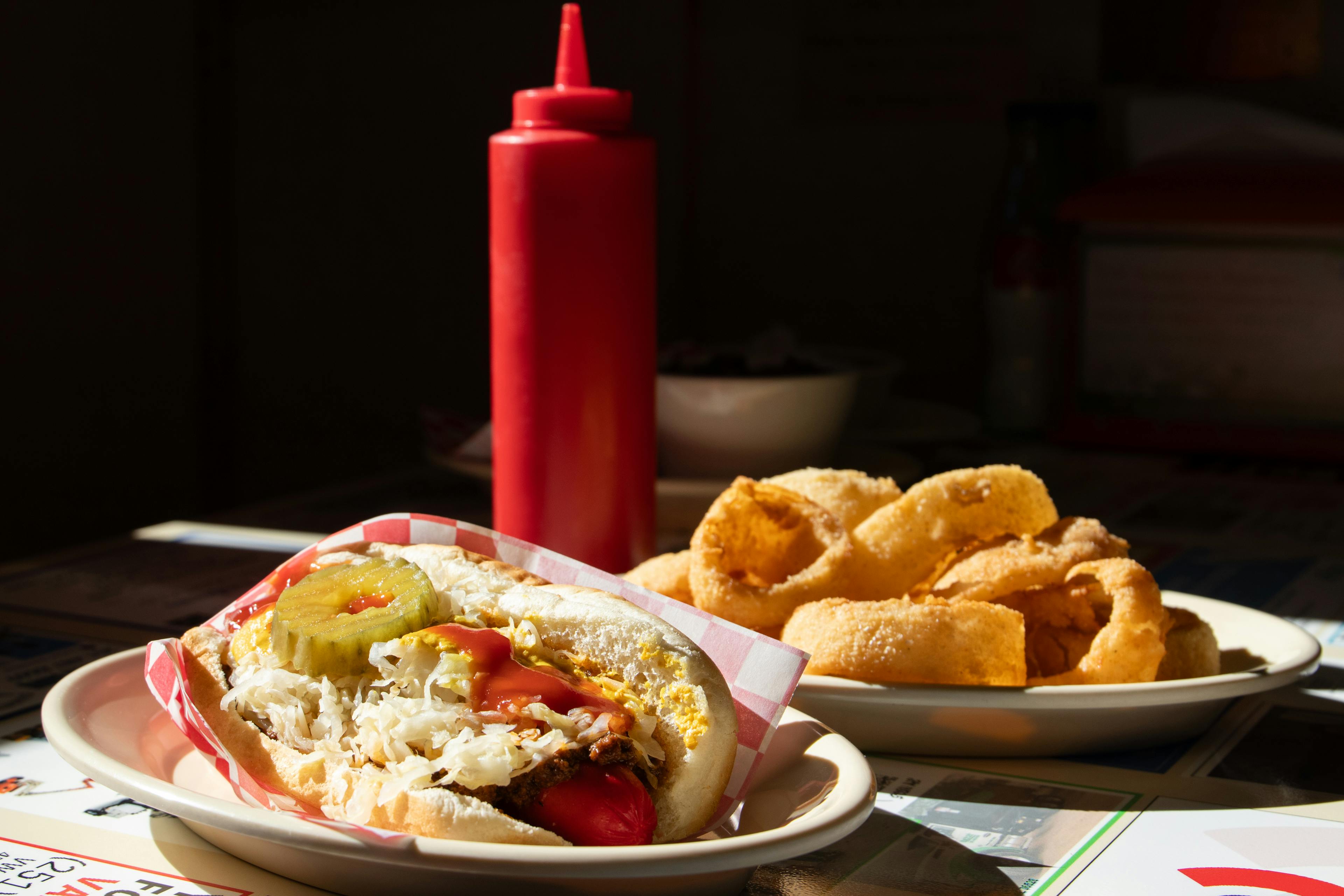 A colonial-era American kitchen hearth with cast iron cookware and traditional cooking tools, representing centuries of American culinary heritage
