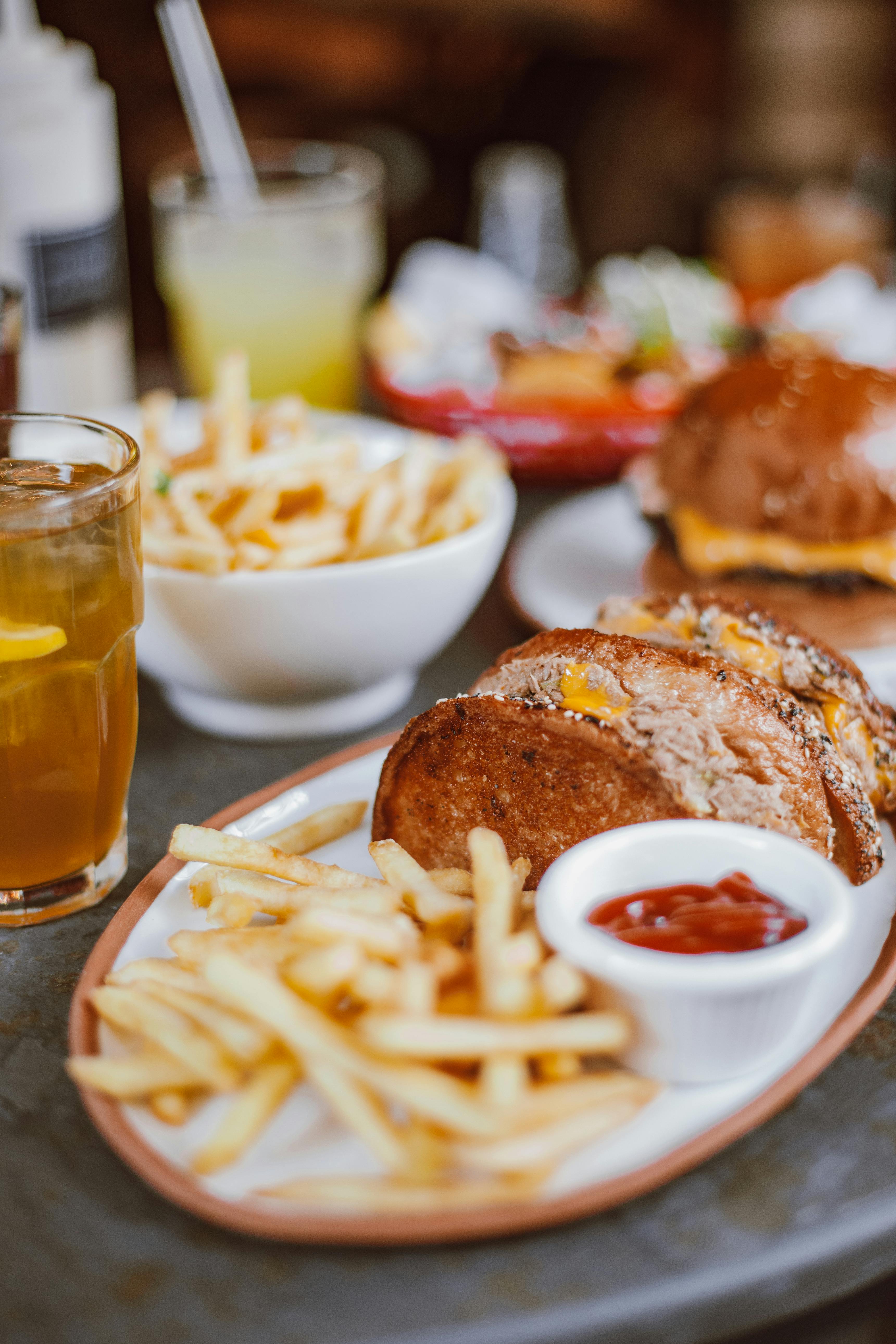 Colonial-era open hearth with cast iron pots and a roaring wood fire, showing traditional American fireplace cooking methods from the 1700s